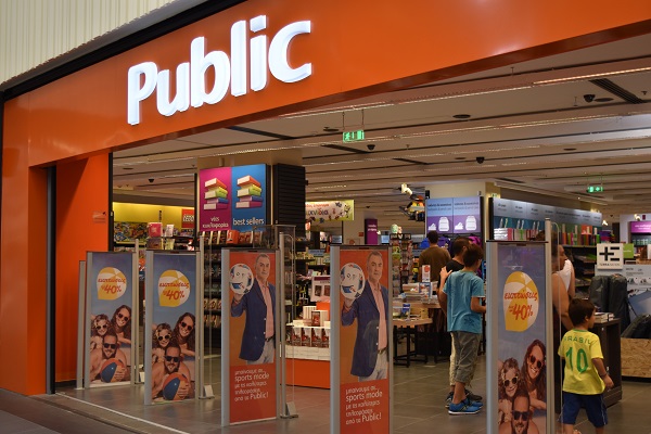 Front of Public in Cosmos. A large open entry way with orange sign and book shelves visible inside.