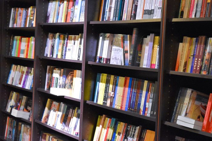 Interior of Гринуич буук център (Greenwich Book Center), bookstore in Sofia, Bulgaria. Rows of books are neatly stacked on black bookshelves.