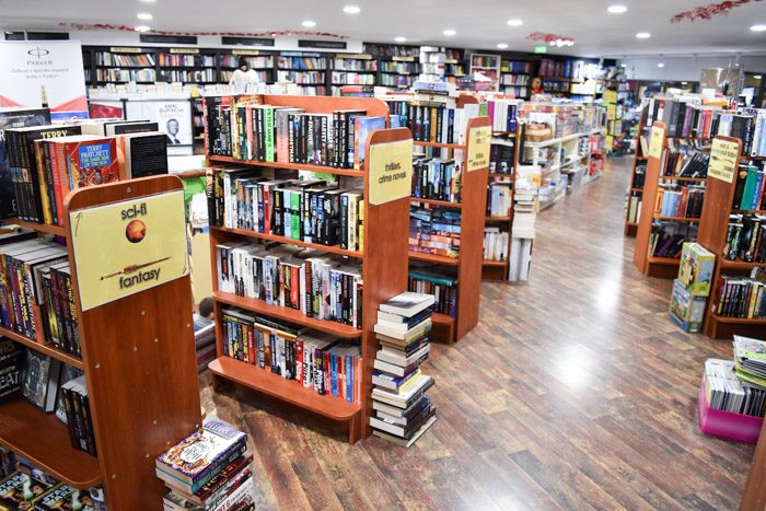 Interior of Сиела (Ciela), bookstore in Sofia, Bulgaria. Wooden bookshelves in rows are filled with neatly stacked books.