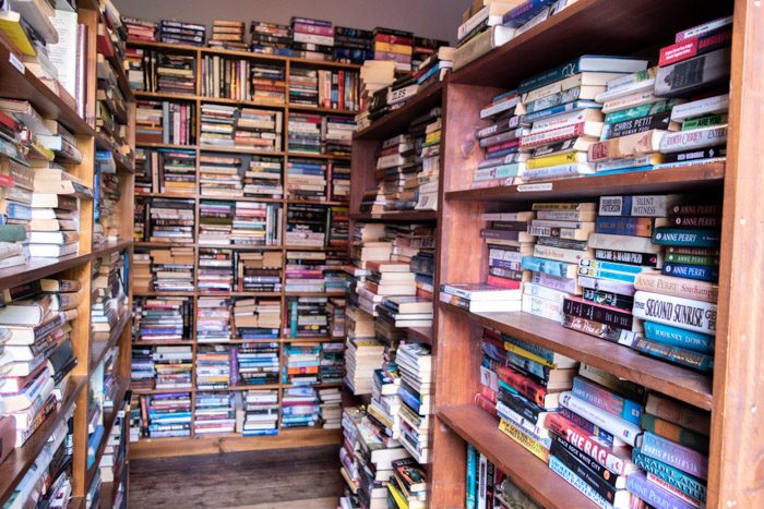 Interior of Aesop's Attic Bookshop, Woodend. Floor to ceiling bookshelves appear on all sides, books are stacked very neatly, mostly horizontally.