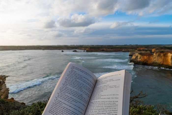 Reading a book at sunset with a view of the bay the Great Ocean Road in Victoria, Australia