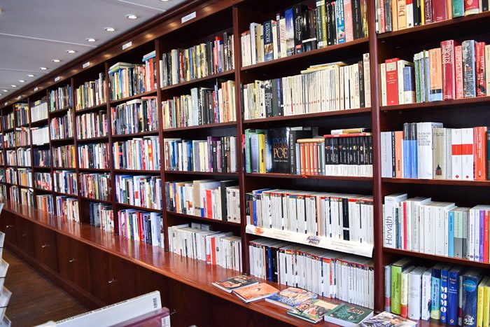 A long row of wooden bookshelves filled with books.