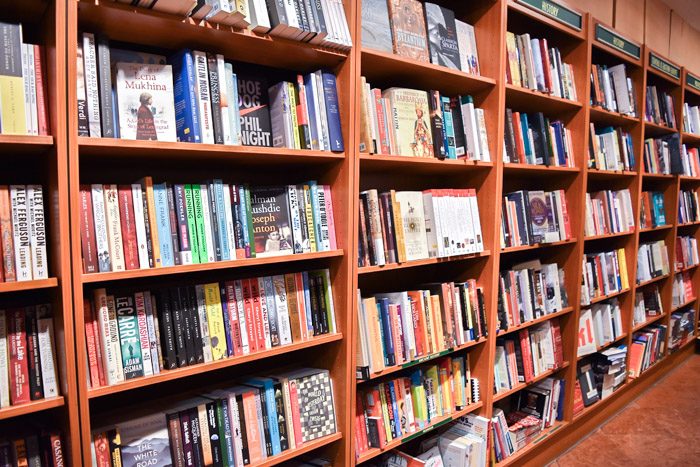 A long row of bookshelves stocked with a variety of books.