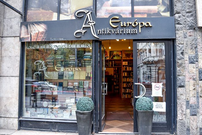 Picture of the front of Europa Antikvarium, which is a black facade and ornate sign lettering above the entrance.