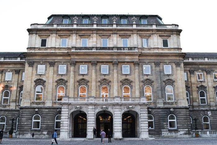 The front of National library, which is a large, austere stone building with arched windows and doorways.