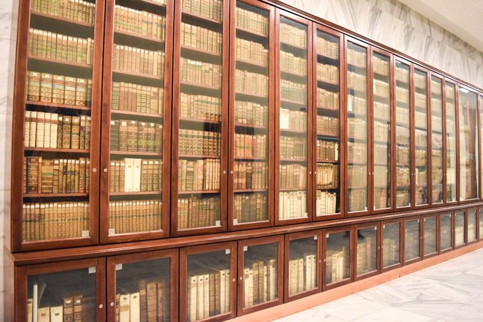 One room of the national library that displays a long row of bookshelves inside glass doors to protect the rare books on display.