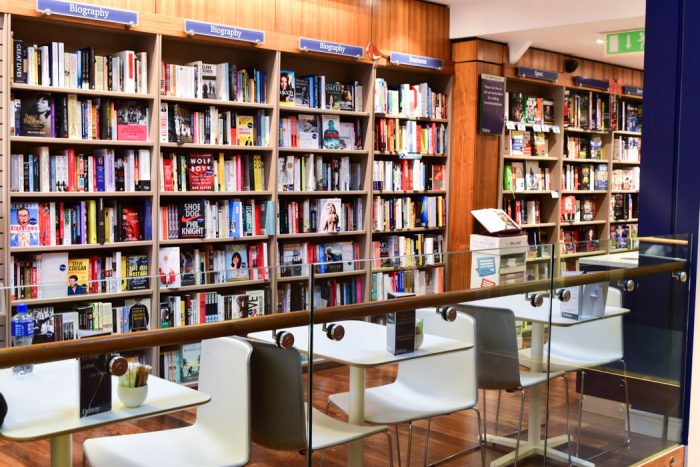 A wall of books and some cafe seating in front of them