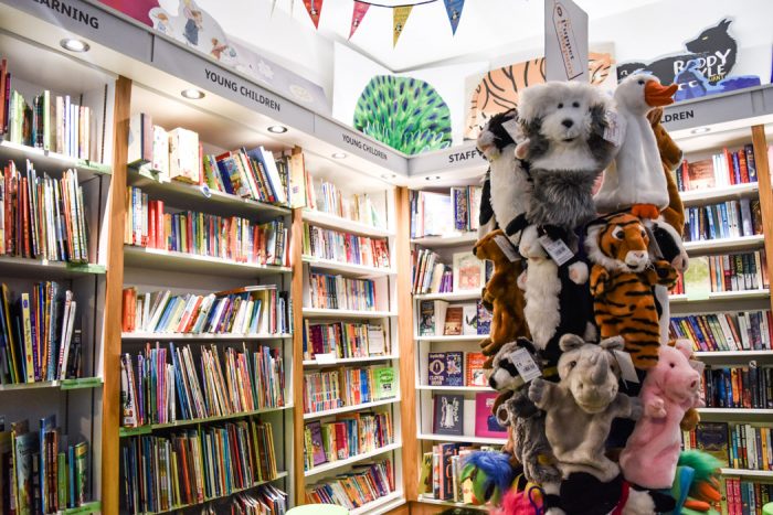 The children's book corner of The Gutter Bookshop with a display stand selling sock puppets