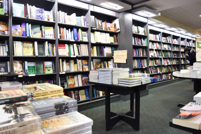 A long wall of books and a small table with more books on display.