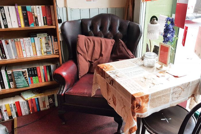 Cozy leather reading chair and small coffee table in the Winding Chair Bookshop