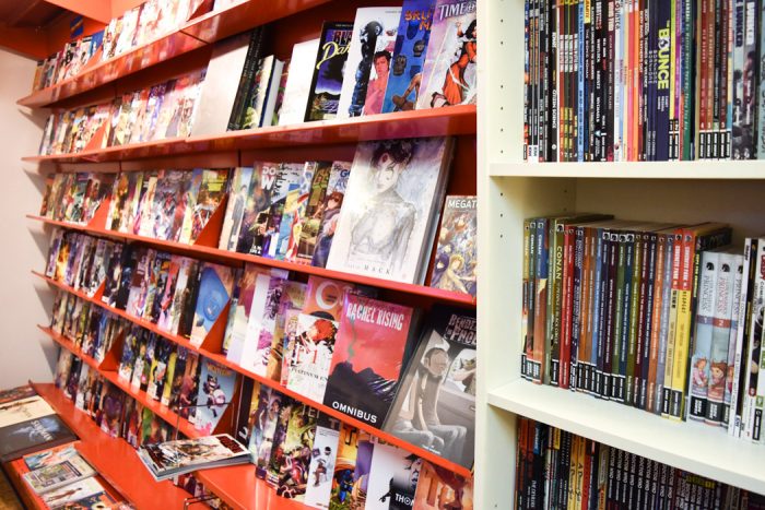 A wall with shelves stocked with a large range of comic books and graphic novels for sale in T3 Terminal Entertainment 