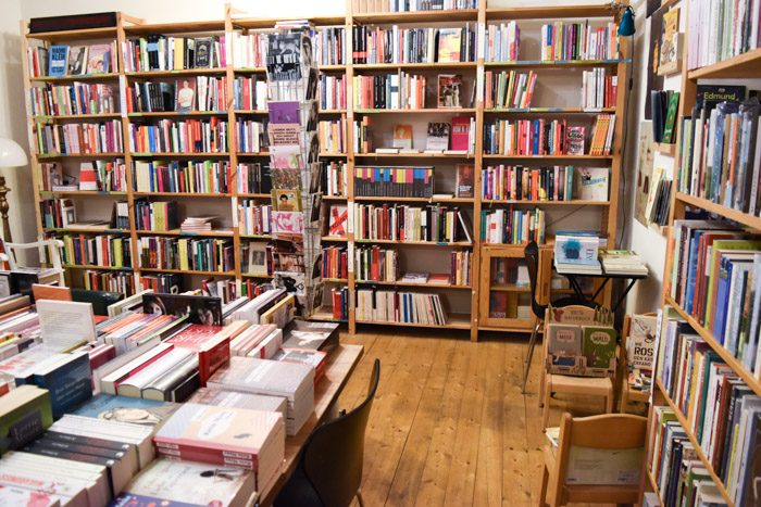 The interior of ChickLit, with wooden floors, large bookshelves and rotating card displays.