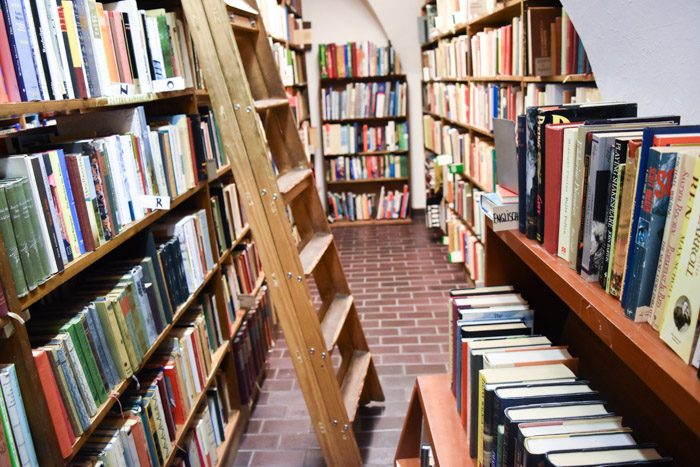 The interior of Der Buchfreund, with tiled floor, bookshelves, and a tall ladder leaning on one bookshelf.