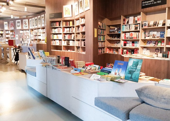 Ocelot bookstore interior with a long wall of bookshelves and a few couches to read on.