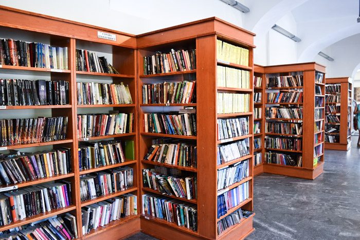 Interior of Belgrade City Library. Wooden bookshelves hold a variety of books. Book Lover's Guide to Belgrade, Serbia.