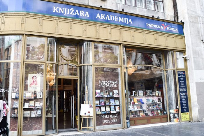 Exterior of Knjizara Akademija. Art deco storefront with lots of books displayed in the windows. Book Lover's Guide to Belgrade, Serbia.